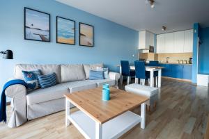 a living room with a couch and a table at Apartamenty Apartinfo Jasny Brzeg in Władysławowo