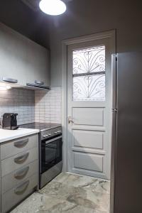 a kitchen with a white door with a window at D Zen Family Apartment Nafplio in Nafplio