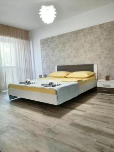 a bedroom with a large bed and a chandelier at Apartament Cezar Faleza-Nord Constanta-Plaja Reyna in Constanţa