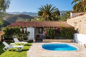 a villa with a swimming pool and two chairs at El Sitio de la Casa in Arico el Nuevo