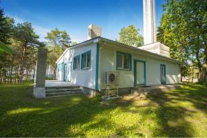 una pequeña casa blanca con una chimenea encima en Puhkekeskus Valkla Rand- Simple accomodation, en Valkla