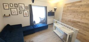 a living room with a blue couch and a window at Cheddar Village Apartment in Cheddar