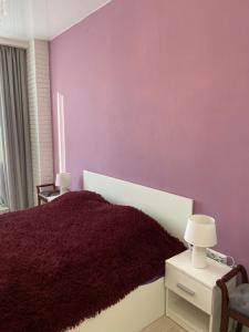 a bedroom with a purple wall and a bed with a red blanket at Французский Бульвар ЖК Париж in Odesa