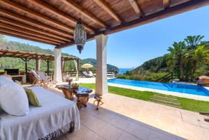 uma vista exterior de uma villa com uma cama e uma piscina em Villa Can Sans em Cala San Vicente