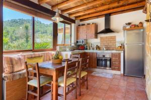 Una cocina con mesa y sillas y un refrigerador. en Villa Can Sans, en Cala San Vicente