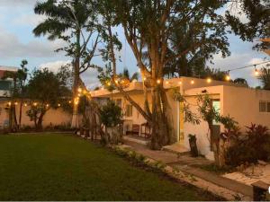 a house with a yard with trees and lights at Casa Borush by Ecoplaneta in Cancún