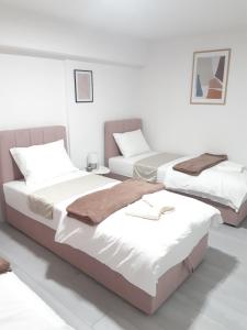 two beds in a room with white walls at Apartman-Stan na dan -Stolac in Stolac