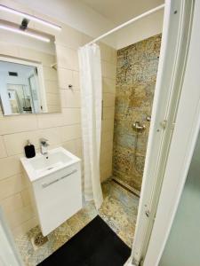ein Bad mit einem Waschbecken und einer Dusche in der Unterkunft Koper2stay Apartments in Koper
