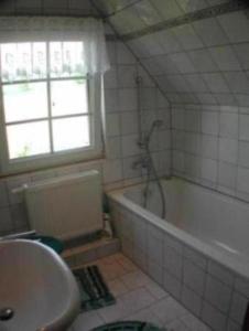 a bathroom with a tub and a sink at Haus Feldmühle in Bad Frankenhausen