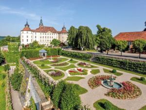 a garden in front of a large white building at Hohenlohe -Residenz-Svetlana in Langenburg