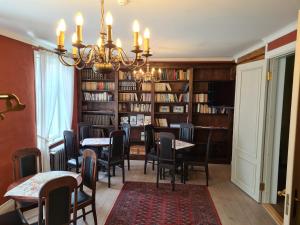 a dining room with tables and chairs and a chandelier at Lahe Guesthouse in Haapsalu