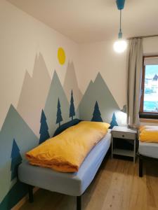 1 dormitorio con 1 cama con un mural de montaña en la pared en Appartamento Engy, en Livigno