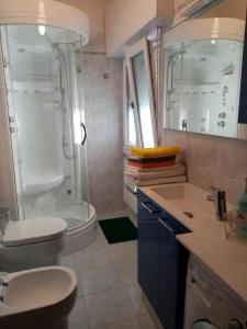uma casa de banho com um WC, um chuveiro e um lavatório. em Appartamento con terrazzo a Gorgonzola em Gorgonzola