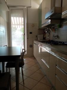uma cozinha com uma mesa e uma mesa e uma mesa; em Appartamento con terrazzo a Gorgonzola em Gorgonzola