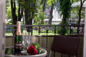 a table with a bowl of flowers and a bottle of wine at City Garden Apartments in Odesa