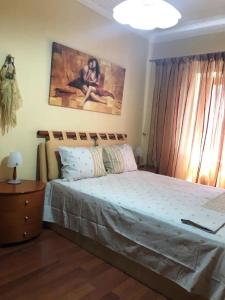 1 dormitorio con 1 cama y una pintura en la pared en Lemnoshouse en Mirina