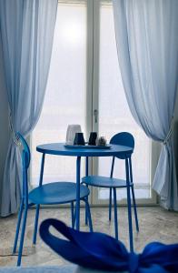 a blue table and two chairs in front of a window at Casa Torrese in Torre del Greco