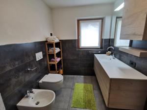 a bathroom with a sink and a toilet and a sink at Appartamento Engy in Livigno