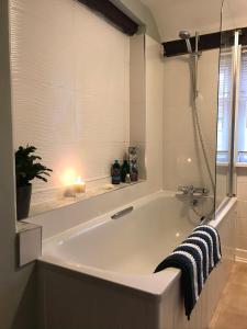 a bath tub with a candle in a bathroom at No 91 The Loft Odiham - Self Catering apartment Min 2 Night stay in Hook