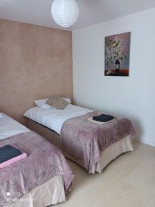 a bedroom with two beds and a picture on the wall at Apartament Pod Wiśnią in Supraśl