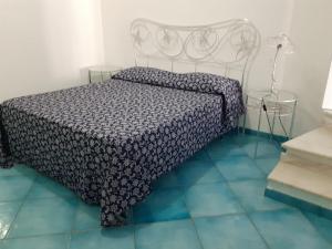 una camera da letto con un letto con un piumone bianco e nero di Da Lucia - Alloggio turistico Santa Maria a Ponza