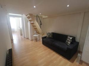 a living room with a black couch and a staircase at Casa Stella in Castel di Sangro +4 photos