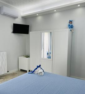 a bedroom with a blue bed with a television on the wall at Casa Torrese in Torre del Greco