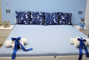 a bed with blue bows on top of it at Casa Torrese in Torre del Greco