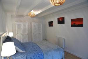um quarto com uma cama azul e duas luzes em Aux Arbres Chanteurs em Ploulech