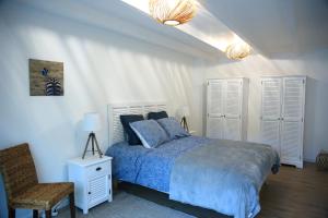 um quarto com uma cama com um edredão azul e uma cadeira em Aux Arbres Chanteurs em Ploulech