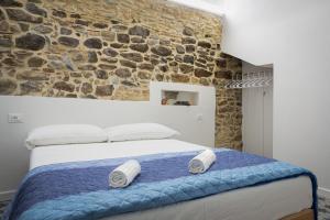 ein Schlafzimmer mit einem Bett mit einer Steinmauer in der Unterkunft Insapria, Caressa de mä in Bordighera