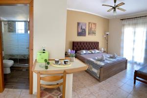 a bedroom with a bed and a table and a dining room at Theodora’s Studios in Repanídhion