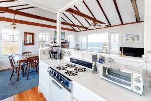 a kitchen with white counters and a stove top oven at North Fork Waterfront Gem in East Marion