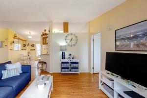 a living room with a blue couch and a large tv at Lighthouse View in Lincoln City