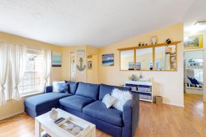 a living room with a blue couch and a table at Lighthouse View in Lincoln City