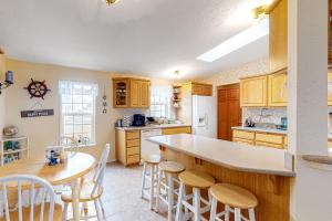 a kitchen with wooden cabinets and a table and chairs at Lighthouse View in Lincoln City +23 photos