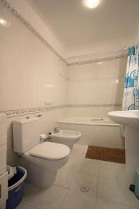 Un baño blanco con inodoro y lavabo. en Apartamento Azur, en Vila Nova de Milfontes 9 fotos más