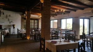 a dining room with tables and chairs and windows at Posada Matadero in Cortelazor