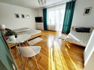 a room with two beds and a table and chairs at Dommieszkalny in Augustów