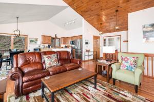 a living room with a leather couch and a table at Fox Run Retreat in Banner Elk