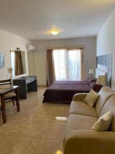 a hotel room with a bed and a couch at Alexia Hotel Apartments in Ayia Napa