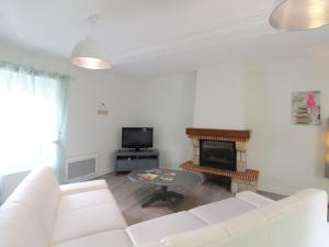 a living room with a white couch and a fireplace at Gîte Chemillé-en-Anjou-Chemillé-Melay, 4 pièces, 6 personnes - FR-1-622-8 in Saint-Georges-du-Puy-de-la-Garde