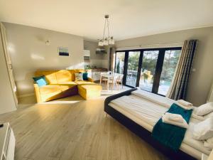 a bedroom with a bed and a living room at Apartamenty Różany Ogród in Łeba