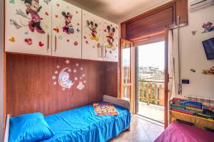 Un dormitorio con una cama azul y una ventana en SWEET HOME LULLABY - free parking, en Passoscuro