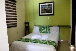 基布多Hotel Ecosuite Quibdó的卧室里有一张带蝴蝶结的床