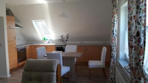 a kitchen with a table and chairs in a room at Ferienwohnung Goden-Wind in Westerdeichstrich