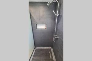 a shower with a shower head in a bathroom at Studio chic et cosy in Cayenne
