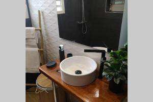 een badkamer met een witte wastafel en een spiegel bij Studio chic et cosy in Cayenne
