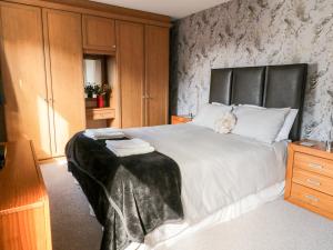 a bedroom with a large white bed with a black headboard at 9 Navigation Square in Skipton