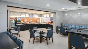 a restaurant with tables and chairs and a counter at Holiday Inn Express Lompoc, an IHG Hotel in Lompoc